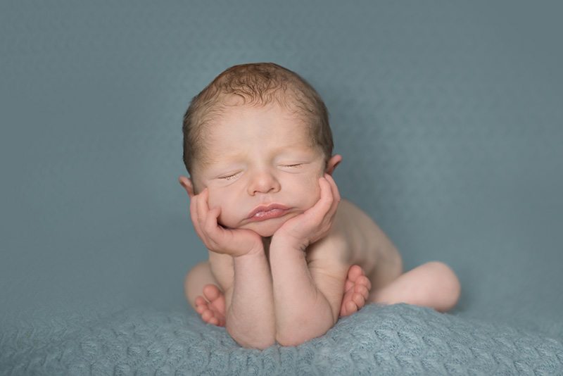 Baby in frog pose wearing a crown safe composite newborn photography Essex.